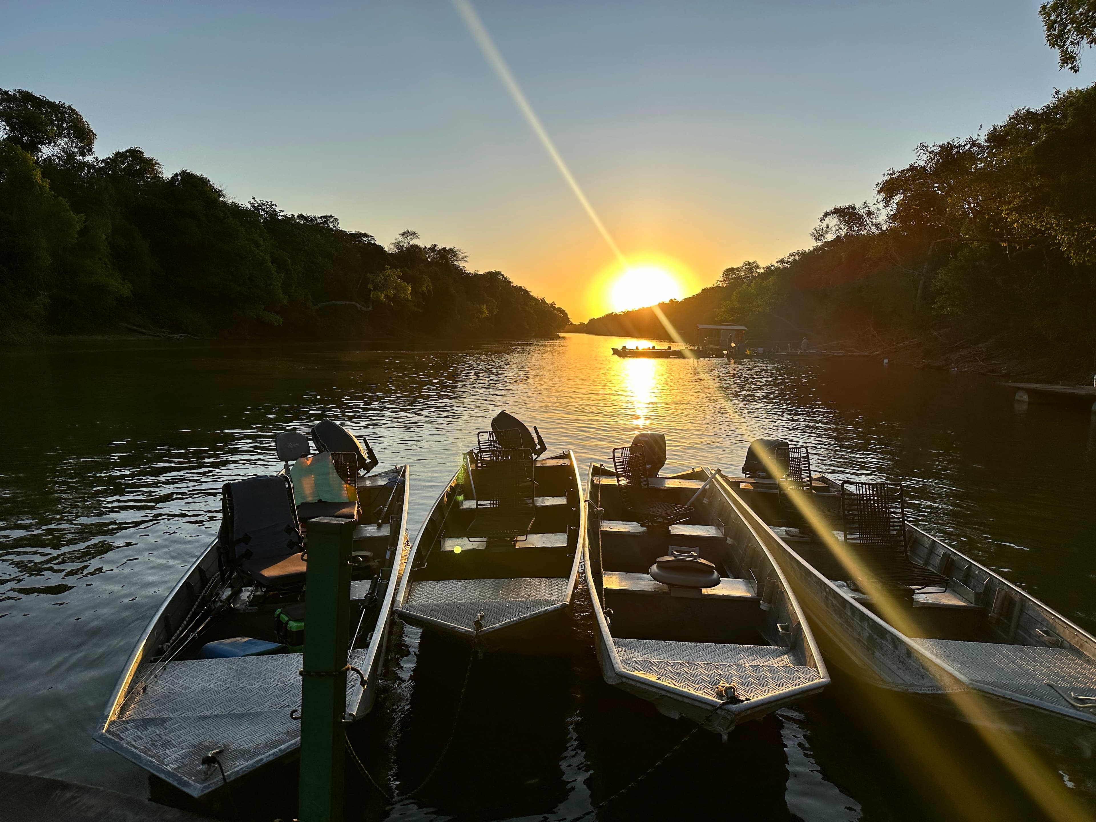 Barcos de pesca de alumínio atracados no rio ao pôr do sol na Pousada Recanto Xingu, Canarana (MT)
