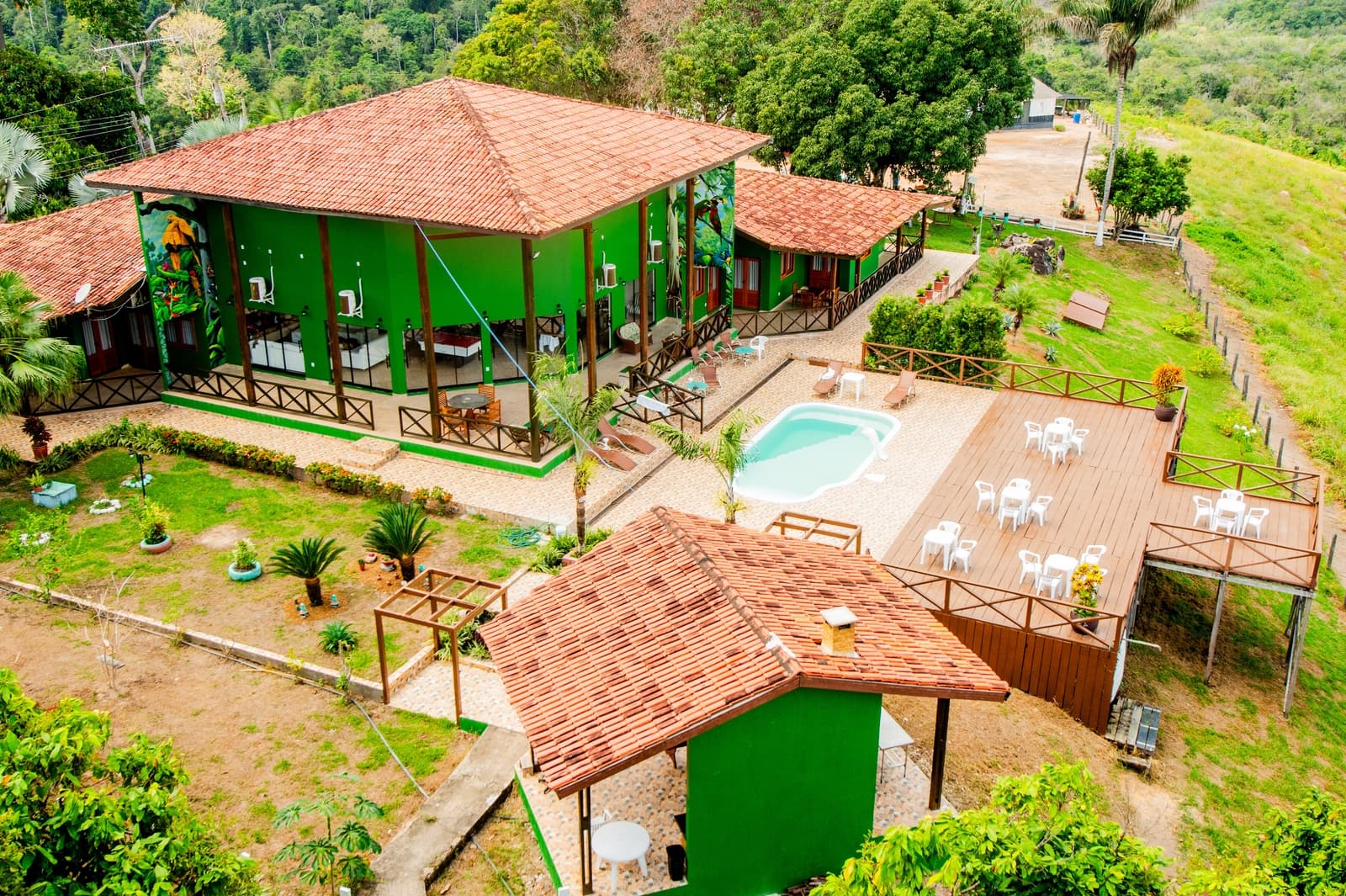 Vista aérea da Pousada Rio Xingu no topo da montanha com piscina e deck cercados por mata
