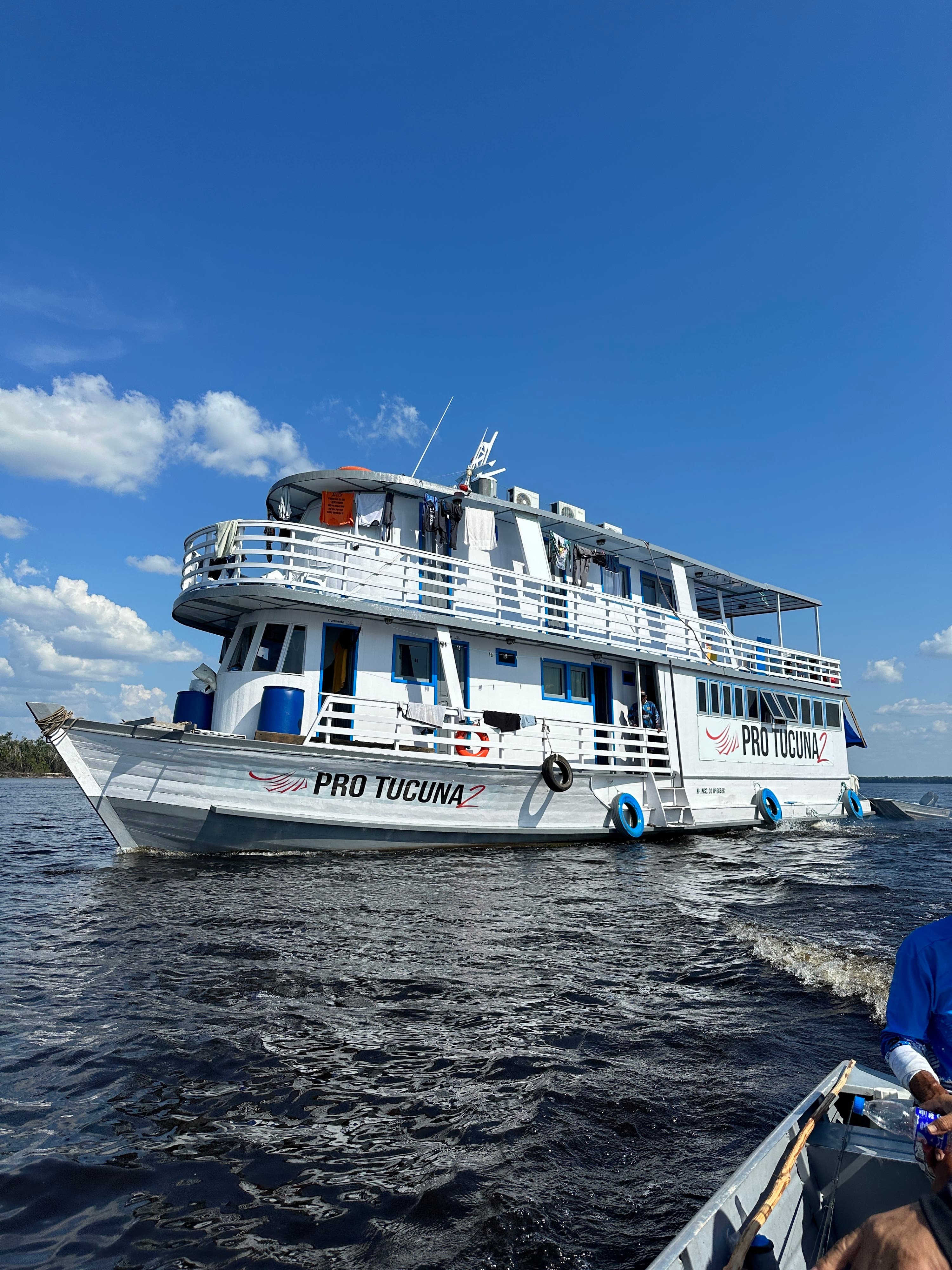 Barco-Hotel Pro Tucuna 2 navegando no Rio Negro em Barcelos, Amazonas — vista lateral com logotipo